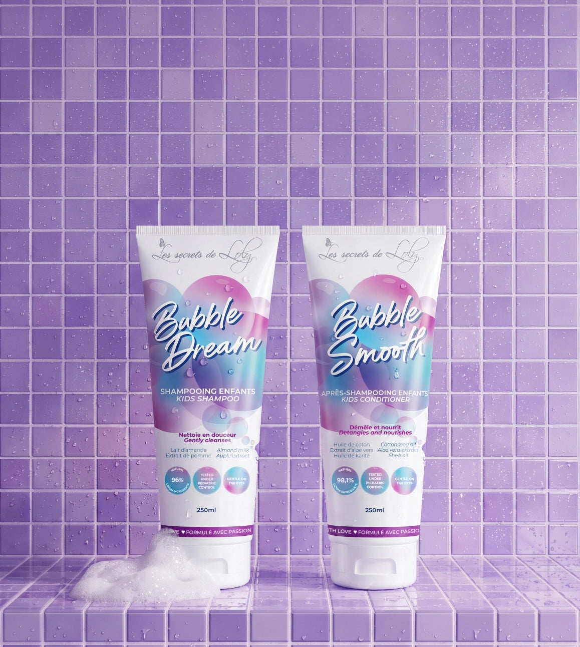Tubes Bubble Dream et Bubble Smooth sur un carrelage violet, avec de la mousse blanche.